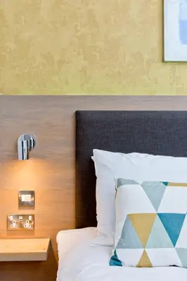 a bedroom with a bed with a wooden headboard at Ultra Modern, West End Village, Refurbished basement appt in Edinburgh