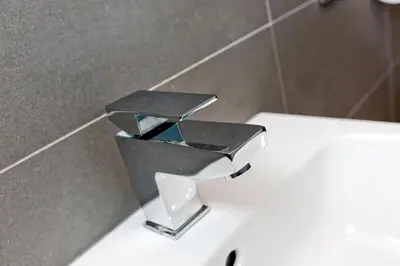 a metal holder on a toilet in a bathroom at Ultra Modern, West End Village, Refurbished basement appt in Edinburgh