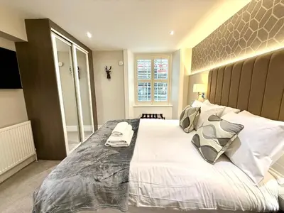a bedroom with a large bed with white sheets and pillows at Ultra Modern, Stylish Apartment Next To Princes St in Edinburgh