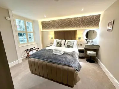 a bedroom with a bed with a desk and a mirror at Ultra Modern, Stylish Apartment Next To Princes St in Edinburgh
