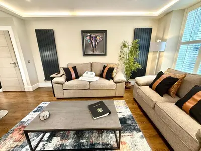 a living room with two couches and a coffee table at Modern 3 Bedroom Apartment, West End in Edinburgh