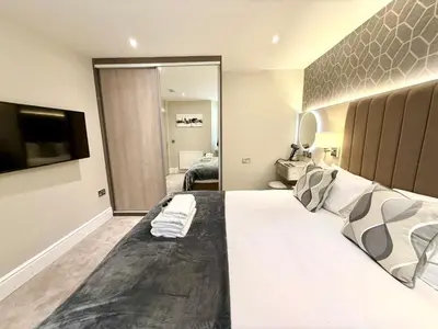 a large bedroom with a large bed with a television at Modern 3 Bedroom Apartment, West End in Edinburgh