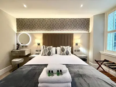 a bedroom with a large white bed with two towels at Modern 3 Bedroom Apartment, West End in Edinburgh