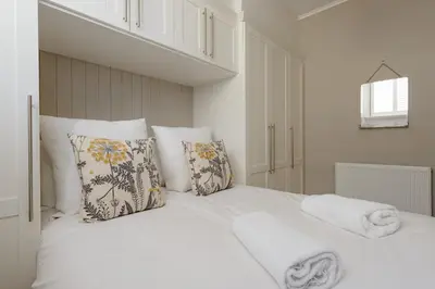 a white bed with white sheets and pillows at The Rose Street Retreat by Calton Living in Edinburgh