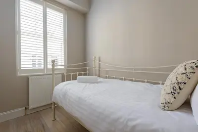 a bedroom with a white bed and a window at The Rose Street Retreat by Calton Living in Edinburgh