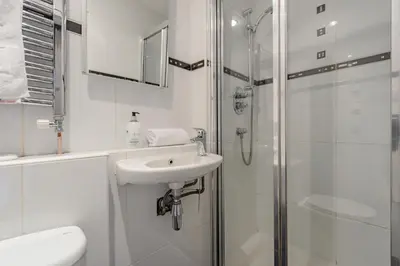 a white bathroom with a sink and a shower at The Rose Street Retreat by Calton Living in Edinburgh