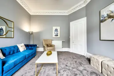 a living room with a blue couch and a table at Lothian Road - perfect city centre location. in Edinburgh