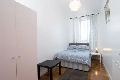 a small bedroom with a bed and a window at 7 Bedroom Townhouse in Edinburgh