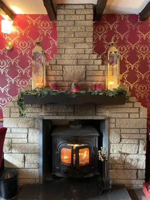 a brick fireplace with a stove with christmas decorations at Dalgarven spa venue in Kilwinning