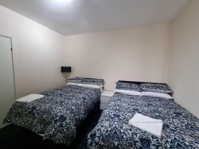 two beds sitting next to each other in a room at Carnarvon Street City Centre Apartment in Glasgow