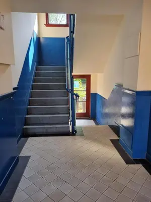 a staircase in a building with blue steps and a door at Carnarvon Street City Centre Apartment in Glasgow