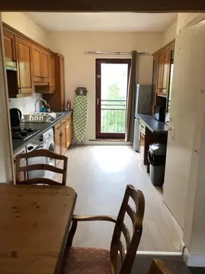 a kitchen with a table and chairs and a refrigerator at Carnarvon Street City Centre Apartment in Glasgow