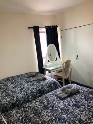 a bedroom with two beds and a mirror and a desk at Carnarvon Street City Centre Apartment in Glasgow