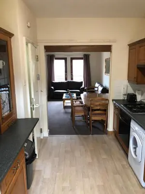 a kitchen and living room with a table and a dining room at Carnarvon Street City Centre Apartment in Glasgow