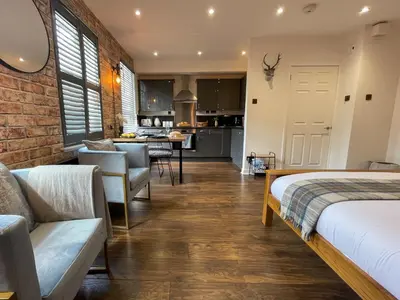 a living room with two beds and a kitchen at Studio Hart Castle Rock Grassmarket in Edinburgh