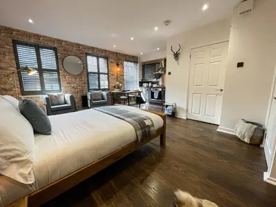 a bedroom with a bed and a brick wall at Studio Hart Castle Rock Grassmarket in Edinburgh