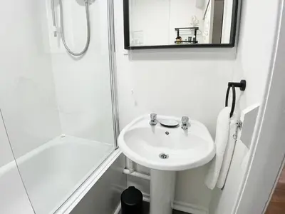 a white bathroom with a sink and a shower at Studio Hart Castle Rock Grassmarket in Edinburgh