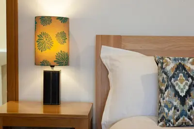 a lamp on a table next to a bed at 5 bed house near Oban in Oban