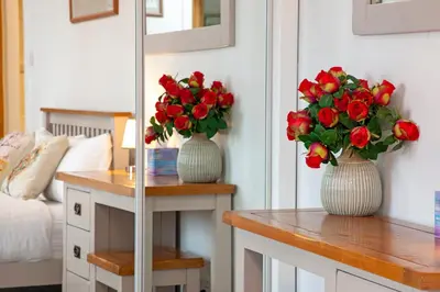 two vases filled with red roses on a table at 5 bed house near Oban in Oban