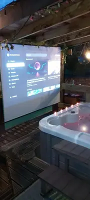 a large screen with a bath tub in a room at The Cabin with optional Hot Tub Projector DEPOSIT REQUIRED FOR PROJECTOR in Bonnybridge