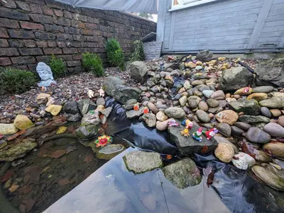 a garden with rocks and figurines in the water at The Cabin with optional Hot Tub Projector DEPOSIT REQUIRED FOR PROJECTOR in Bonnybridge