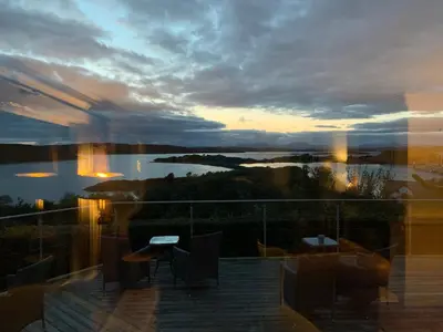 a view of a sunset from the balcony of a house at Corrie House in Craobh Haven