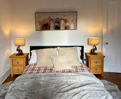 a bedroom with a bed with two lamps and two animals on the wall at Bread street, Central and spacious one bed flat in Edinburgh
