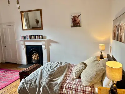 a living room with a fireplace and a bed at Bread street, Central and spacious one bed flat in Edinburgh