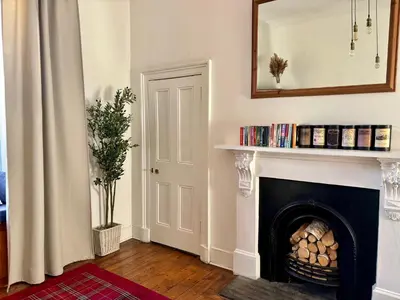 a living room with a fireplace and a mirror at Bread street, Central and spacious one bed flat in Edinburgh
