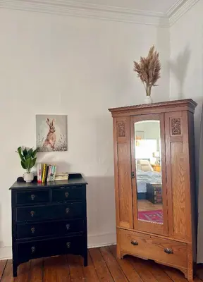 a bedroom with a dresser and a mirror and a cabinet at Bread street, Central and spacious one bed flat in Edinburgh