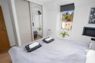 a white bedroom with a large bed with two pillows on it at Charming Apt nr Centre - Terrace & Street Parking in Oban