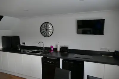 a kitchen with a clock on the wall and a sink at The Annexe at Loch View Farm in Crieff