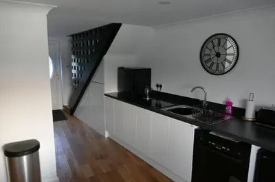 a kitchen with a sink and a clock on the wall at The Annexe at Loch View Farm in Crieff