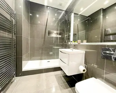 a bathroom with a shower and a toilet and a sink at Gorgeous 2BR & Central Edinburgh Bolt-hole in Edinburgh
