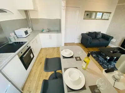 a kitchen and living room with a table and a couch at The Sleeping Lion - Dunoon Holiday Home in Dunoon