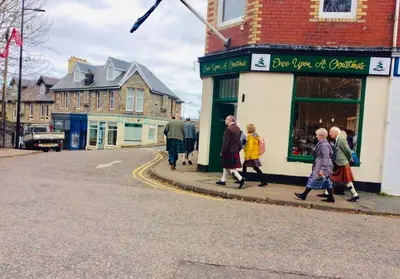 a group of people walking down a street at The Sleeping Lion - Dunoon Holiday Home in Dunoon