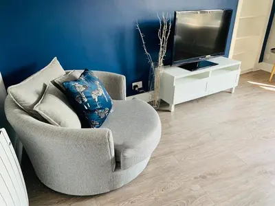 a living room with a chair and a television at No7 Oban Harbour in Oban