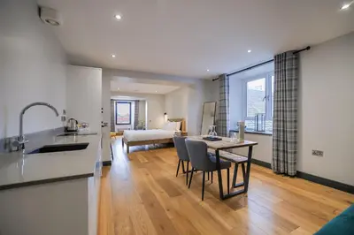 a kitchen and living room with a table and chairs at Oban Bay Apartments in Oban