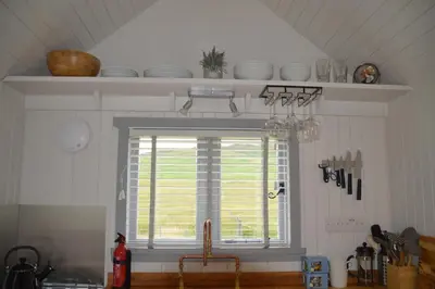 a kitchen with a window above a kitchen sink at Corriemuckloch Unique Huts in Dunkeld