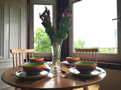 a wooden table with a vase of flowers on it at Forth View Apartment in Stirling