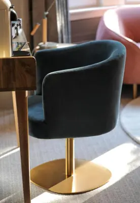 a black chair on a gold stand next to a table at Boutique 50 in Glasgow