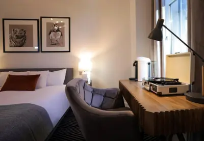 a bedroom with a bed and a desk and chairs at Boutique 50 in Glasgow