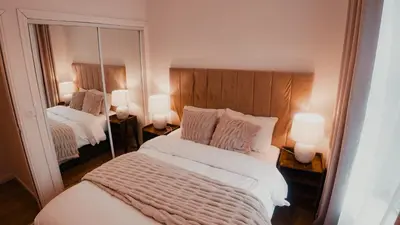 a bedroom with a bed and a mirror at Royal Chambers Serviced Apartments in Glasgow
