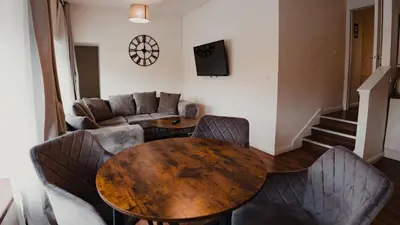 a living room with a wooden table and chairs at Royal Chambers Serviced Apartments in Glasgow