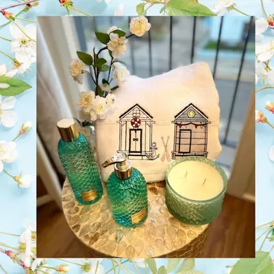 a table with two green glass vases and a candle at Riverside View Apartment in Balloch, Loch Lomond in Balloch