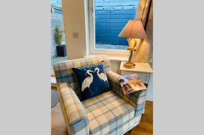 a living room with a chair and a lamp at Riverside View Apartment in Balloch, Loch Lomond in Balloch