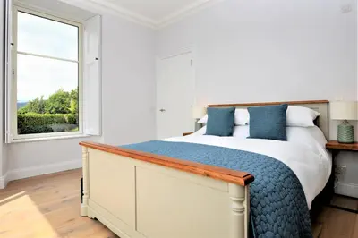 a bedroom with a large bed and a window at Greenlea in Strachur
