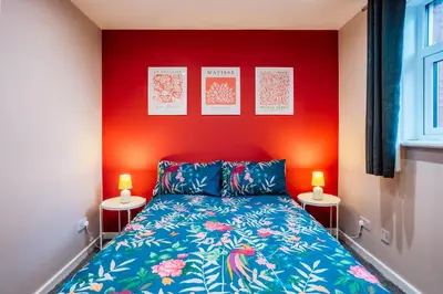 a bedroom with a bed and two lamps on two tables at Dalmarnock Stay in Glasgow
