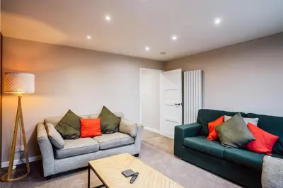 a living room with two couches and a table at Dalmarnock Stay in Glasgow