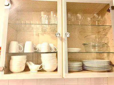 a cabinet with plates and cups and dishes in it at Central 1-Bed Apt Sleeps 4 5 mins to Station in Greenock